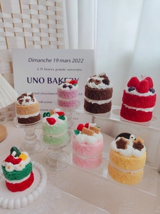 Detailed view of assorted strawberry and chocolate cake scented candles on a clear shelf