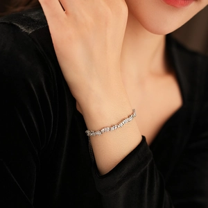 Detail of adjustable silver star pearl bracelet with sparkling zircons on a model's wrist