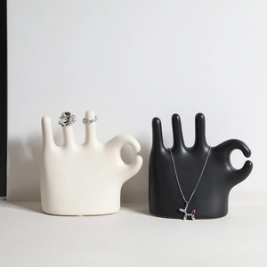 Minimalist ceramic hand-shaped jewelry stands in matte black and white for rings and necklaces