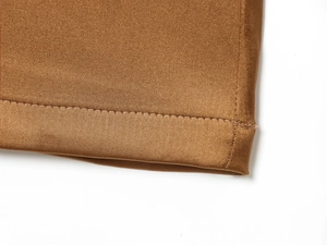 Macro view of stitching on bronze satin wide leg trousers showing fabric texture