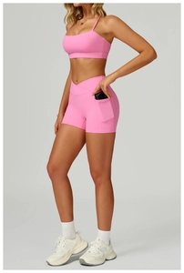 Pink high-waist yoga set featuring a functional side pocket on tight sports shorts