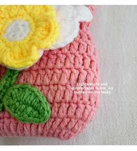Handmade crochet mini flower bag detail, showing cute yarn knit texture and petal design.
