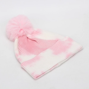 Close-up of pink and white tie-dye knit beanie featuring a soft faux fur pom-pom detail