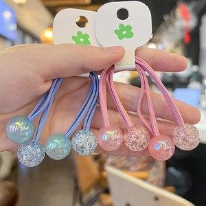 Detail of candy-colored beaded hair ties in blue and pink with glitter resin spheres
