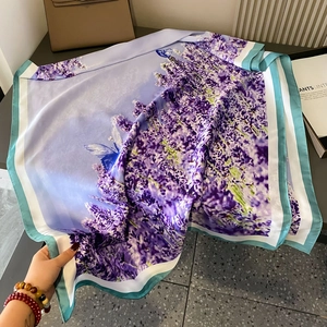 Long lavender silk-like scarf with butterfly print and teal border held by hand
