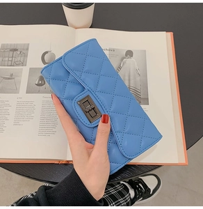 Detail view of a sky blue quilted long wallet with a black vintage metal twist lock