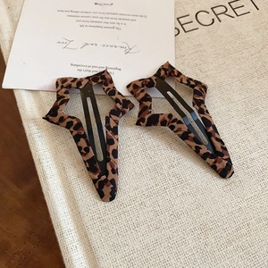Dettaglio di fermagli per capelli a forma di stella con stampa leopardata e clip BB