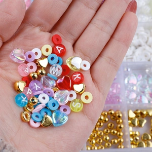 Close-up of colorful heart beads and alphabet charms held in hand for DIY jewelry making