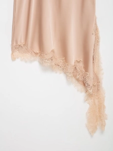 Detailed view of champagne satin dress hem featuring delicate eyelash lace trim detail