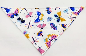 Detail of pet bandana featuring colorful butterfly and dragonfly prints on white fabric