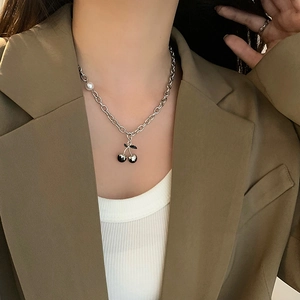 Close-up of hip-hop silver chain necklace with black cherry pendant and a white pearl