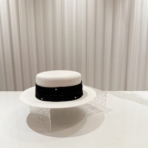 Detail of French boater straw hat with black ribbon and embedded pearl accents