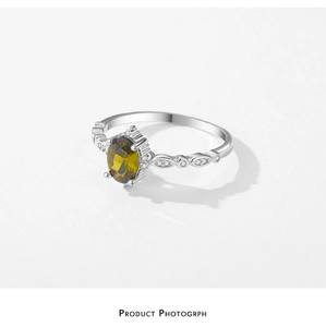 Macro view of s925 silver ring with oval olive green gemstone and pavé white zircons