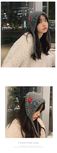 Detail of grey knitted ear warmers with hand-embroidered flowers and long tassels