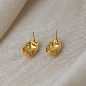 Chic 18K gold plated stainless steel C-shaped striped earrings on beige textured fabric
