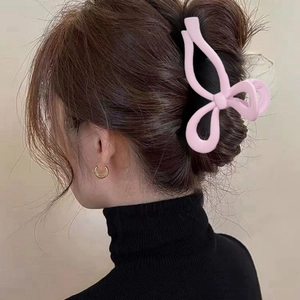 Pink butterfly hair claw clip with matte hollow design worn on a model's ponytail