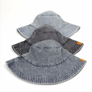 Tre cappelli a secchiello in denim lavato vintage in varie tonalità di blu con etichette arancioni
