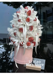 Detail of creative strawberry gift box with white feathers and ribbon on pink base