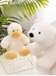 Close-up of soft plush duck and polar bear toys in a cozy decorative gold basket