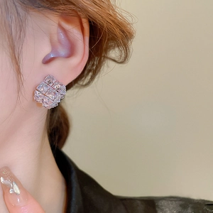 Close-up of geometric cubic zircon earrings worn on a model for a minimalist fashion look