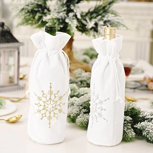 Detail of white velvet Christmas wine bags with gold and silver snowflake embroidery