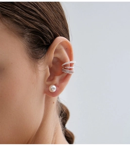 Close-up of model wearing silver three-layer pearl ear cuff with zircon accents