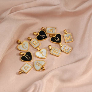 Collection of gold heart and square letter pendants on soft satin fabric