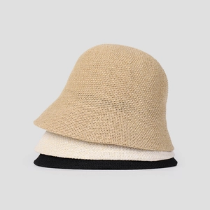Three minimalist knitted bucket hats in khaki, beige, and black with fine woven texture