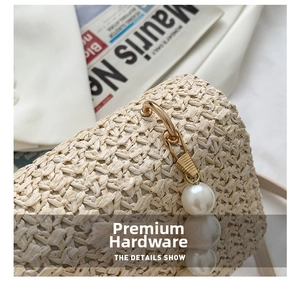 Close-up of beige straw woven texture with golden metal clasp and white pearl charm detail