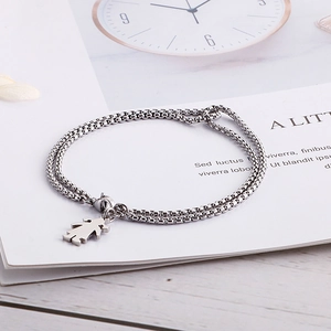 Dettaglio del bracciale a doppio strato argento con ciondolo bimba su pagina bianca