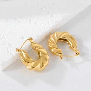 Vue détaillée de boucles d'oreilles croissant dorées sur une pierre blanche