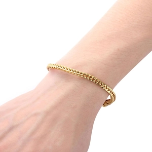 Close-up of gold titanium steel bracelet for men with woven link design and metallic shine