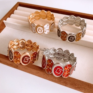 Detail of vintage elastic bracelets with oval enamel links and decorative star motifs