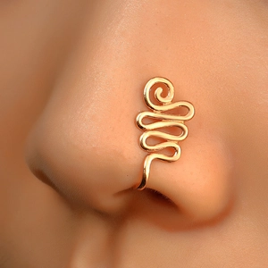 Macro shot of a non-pierced golden copper nose clip with spiral snake design on model