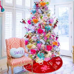 Detail of red Valentine tree skirt with Love text and hearts under white holiday tree
