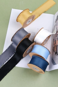 Détail de rubans en satin à volants colorés disposés sur une page de magazine rétro