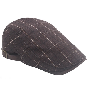 Detail of brown plaid ivy cap featuring an adjustable rear strap and bronze metal buckle