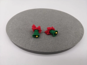 Nahaufnahme der Weihnachtsglocken-Ohrstecker mit roter Schleife und grüner Farbe