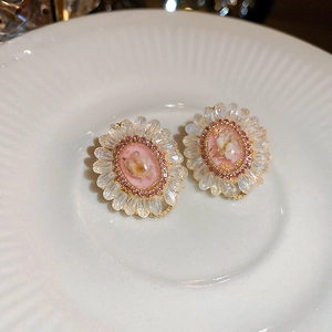 Macro detail of vintage floral crystal earrings with pink flower and silver needles