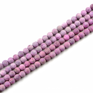 Makro-Detail von natürlichen lila Steinperlen mit matter poröser Textur für DIY-Schmuck