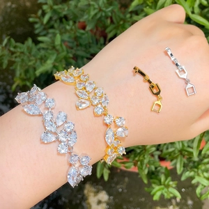 Elegant gold and silver leaf bracelets with brilliant zircons shown on a wrist