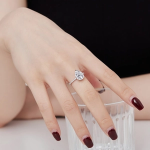Pear-cut water drop silver ring with halo stones and pavé band on model's hand