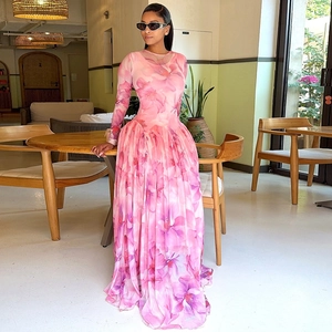Détail d'une robe longue en mousseline fleurie avec taille plissée et manches longues