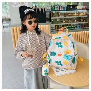 Detailed view of floral print kids backpack with a matching mini coin purse hanging