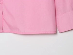 Detail of pink embroidered blouse showing precision stitching on hem and cuffs