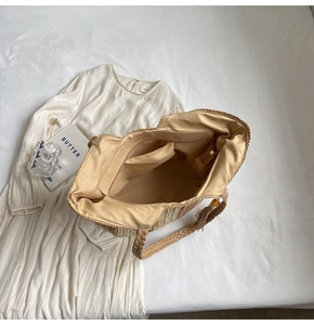 Detailed interior of vertical stripe straw tote bag showing zipper pocket and fabric lining