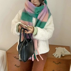 Detail of soft pastel plaid scarf in green, pink, and purple with fringe tassels