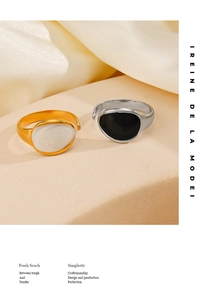 Close-up of gold and silver enamel rings on a minimalist beige fabric backdrop