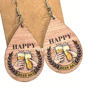 Détail de boucles d'oreilles en bois en forme de goutte avec motif Happy Beer Day