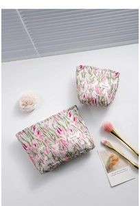 Detail of tulip embroidery on white fabric cosmetic bag set with natural shadows